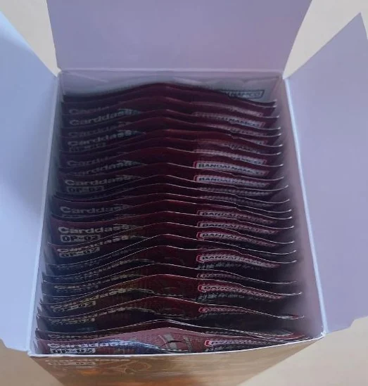 An opened One Piece booster box seen from above, the sealed booster packs standing in rows inside it, each pack showing its factory printing.